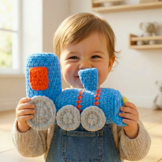 Smiling child holding a blue crochet train plushie, handmade amigurumi toy, cozy home setting