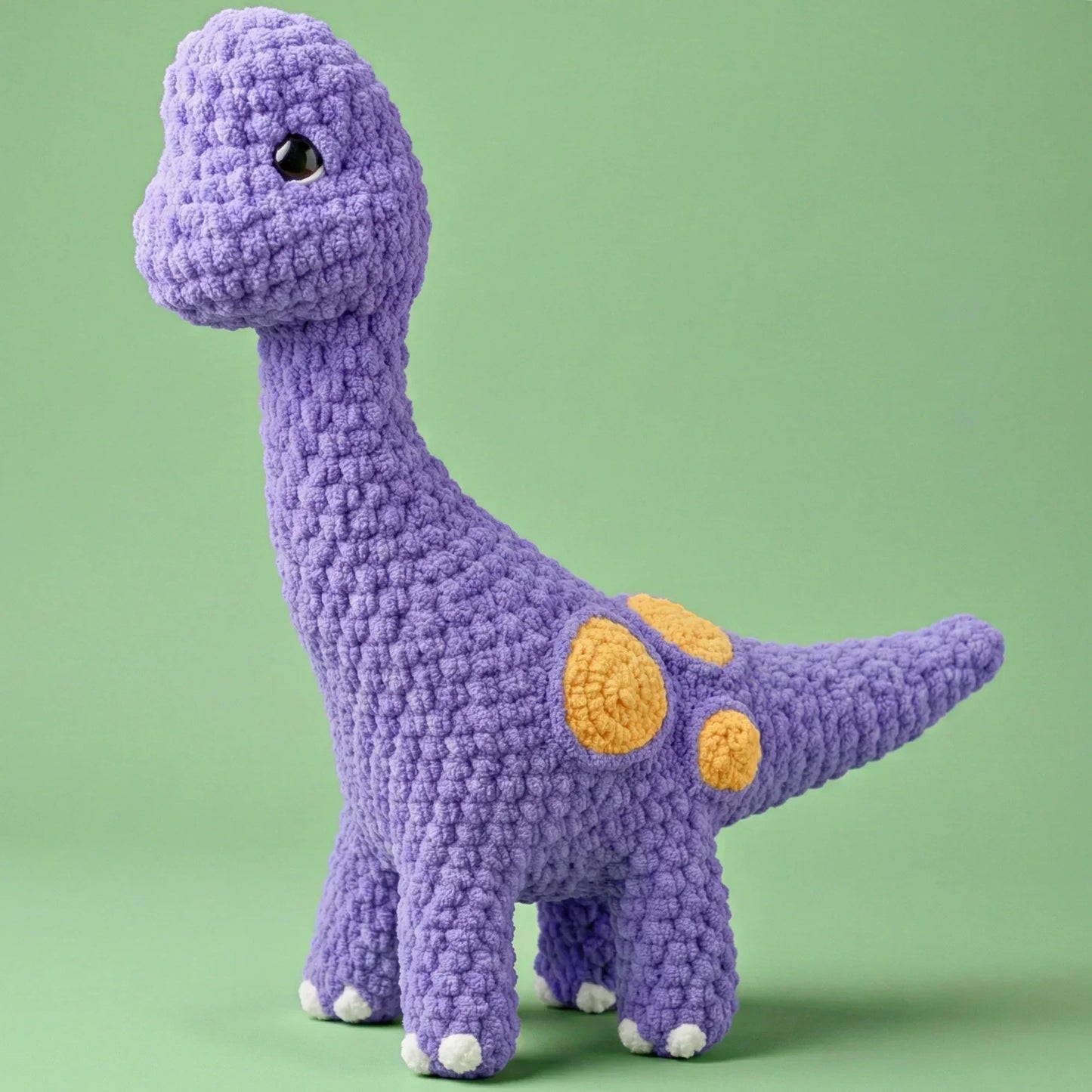 Purple crochet brontosaurus plushie with yellow spots, amigurumi dinosaur toy pattern