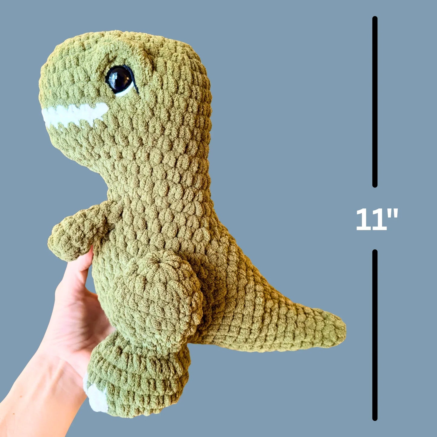 Hand holding green crochet dinosaur plush, 11 inches tall, amigurumi stuffed animal pattern