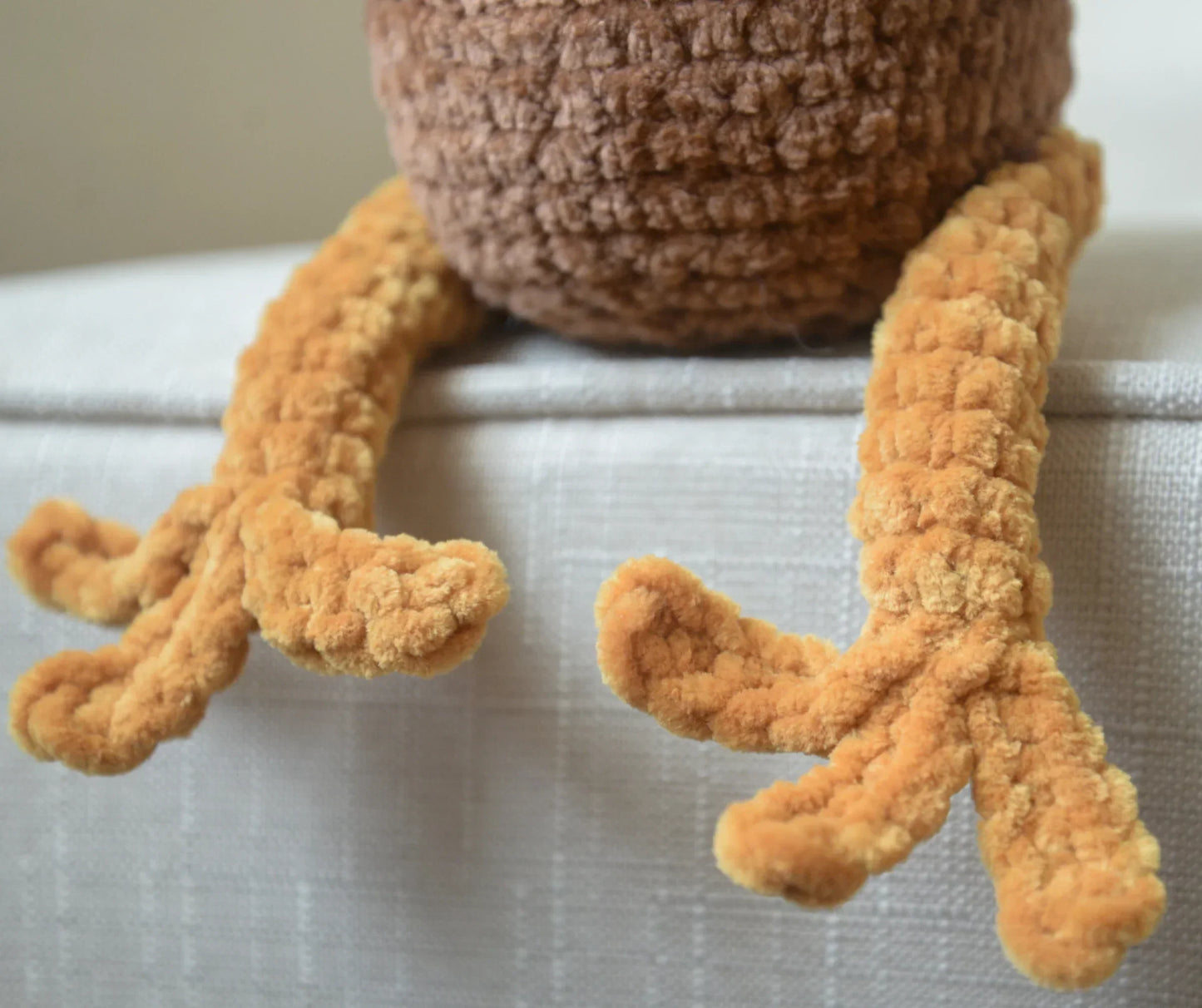 Close-up of plush crochet turkey legs and body, soft textured amigurumi toy