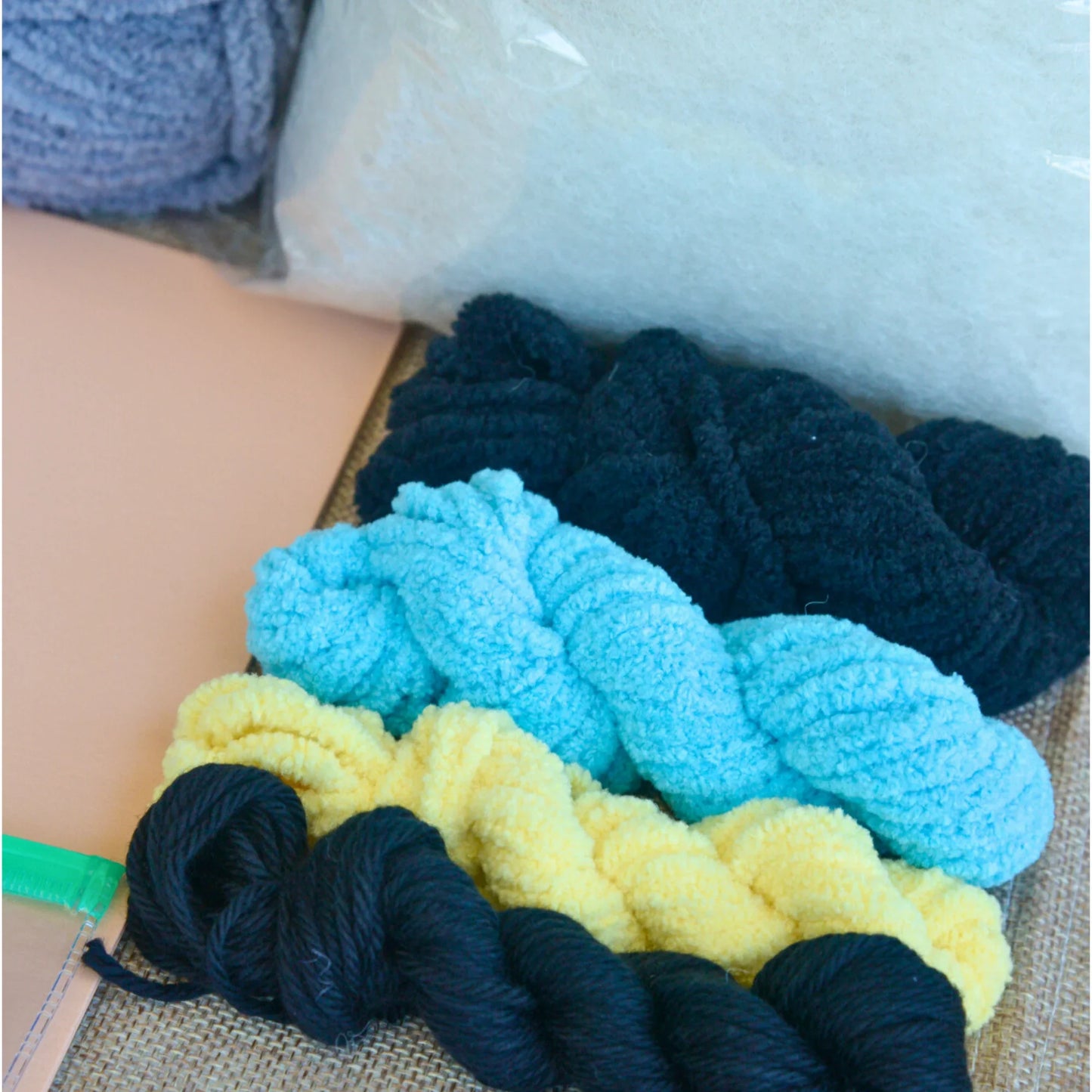 Colorful skeins of blue, yellow, and black plush yarn for crochet projects