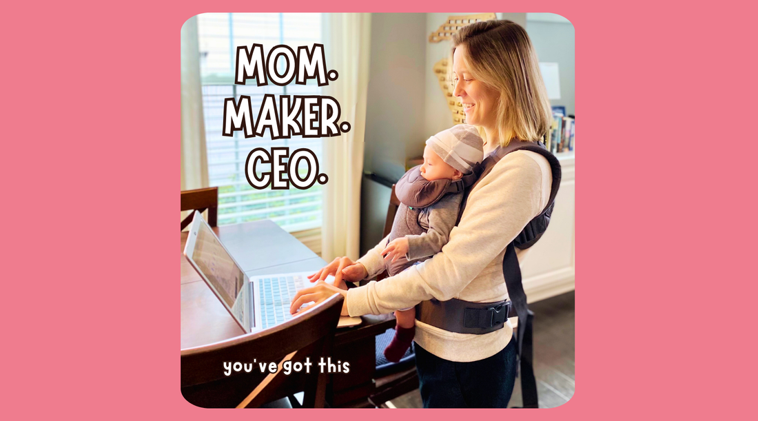 Smiling mom working on laptop with baby in front carrier at home, text Mom Maker CEO