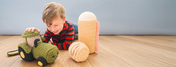 boy playing with crochet farm