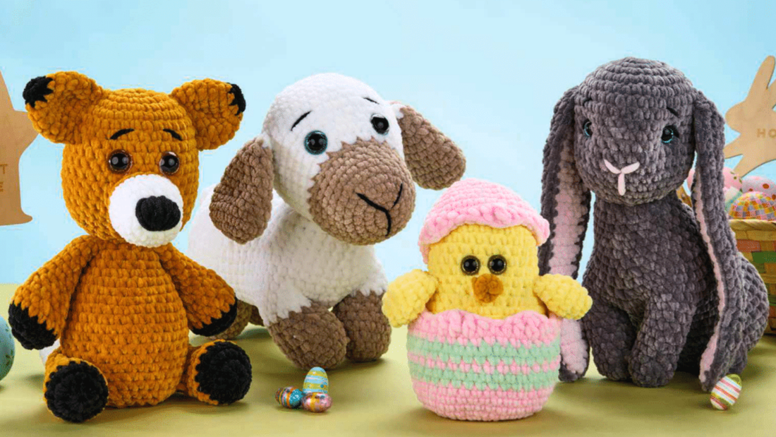Four crocheted plush toys: a brown bear, white and brown dog, yellow chick in pink wrapping, and gray bunny with long ears