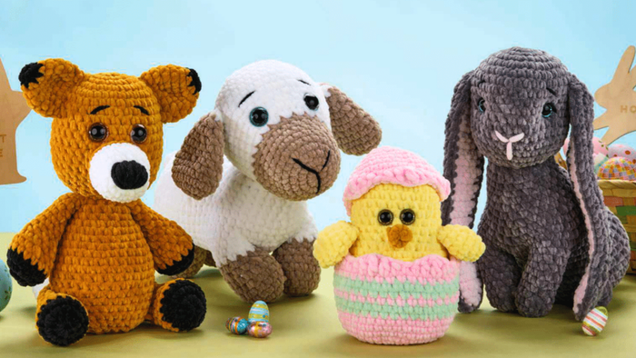 Four crocheted plush toys: a brown bear, white and brown dog, yellow chick in pink wrapping, and gray bunny with long ears