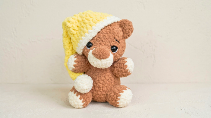 Crochet stuffed bear plushie with yellow and white hat, amigurumi beginner pattern