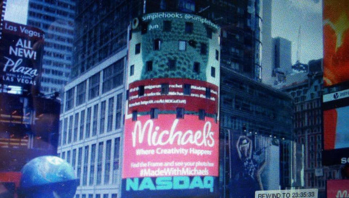 Times Square digital billboard showcasing crochet plushie pattern ad with city buildings