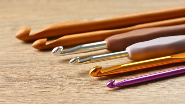 Assorted colorful crochet hooks for amigurumi and beginner crochet projects on wood surface