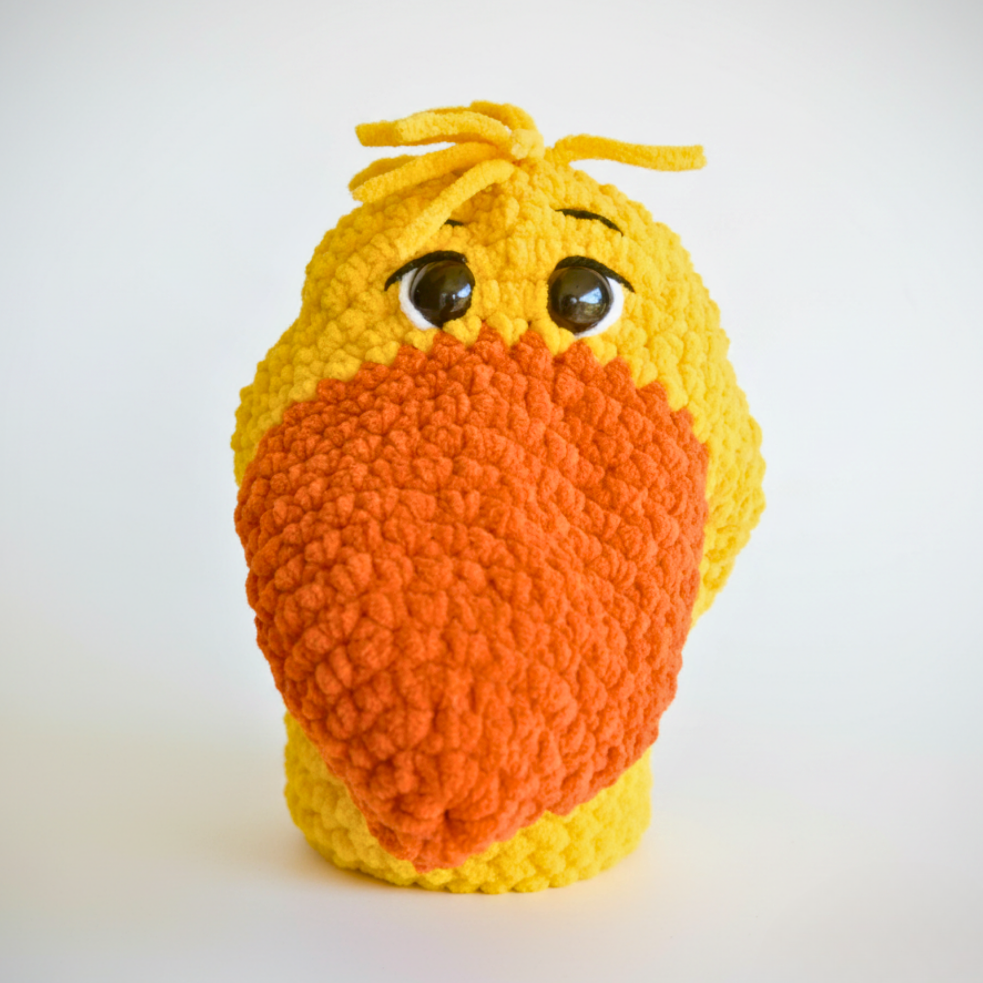 Handmade yellow crochet bird plush with big orange beak and expressive eyes