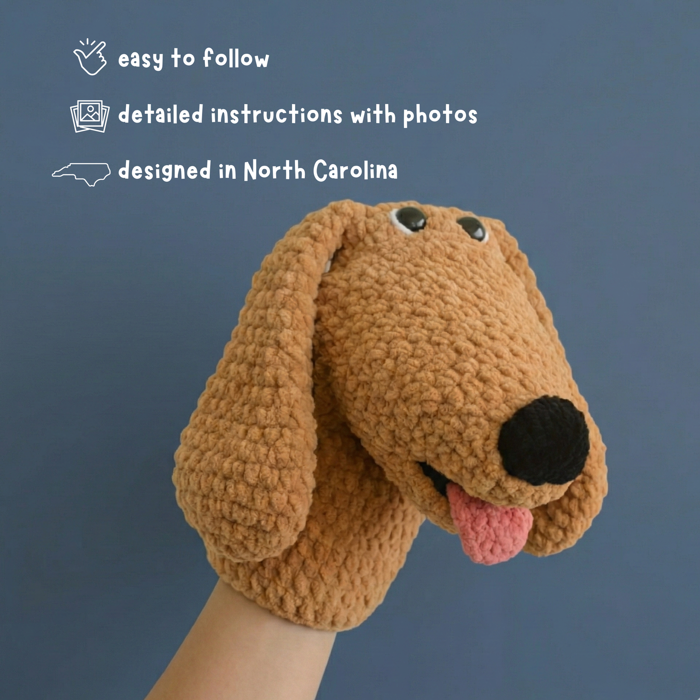 Hand wearing a brown crocheted dog puppet with floppy ears and tongue against blue background
