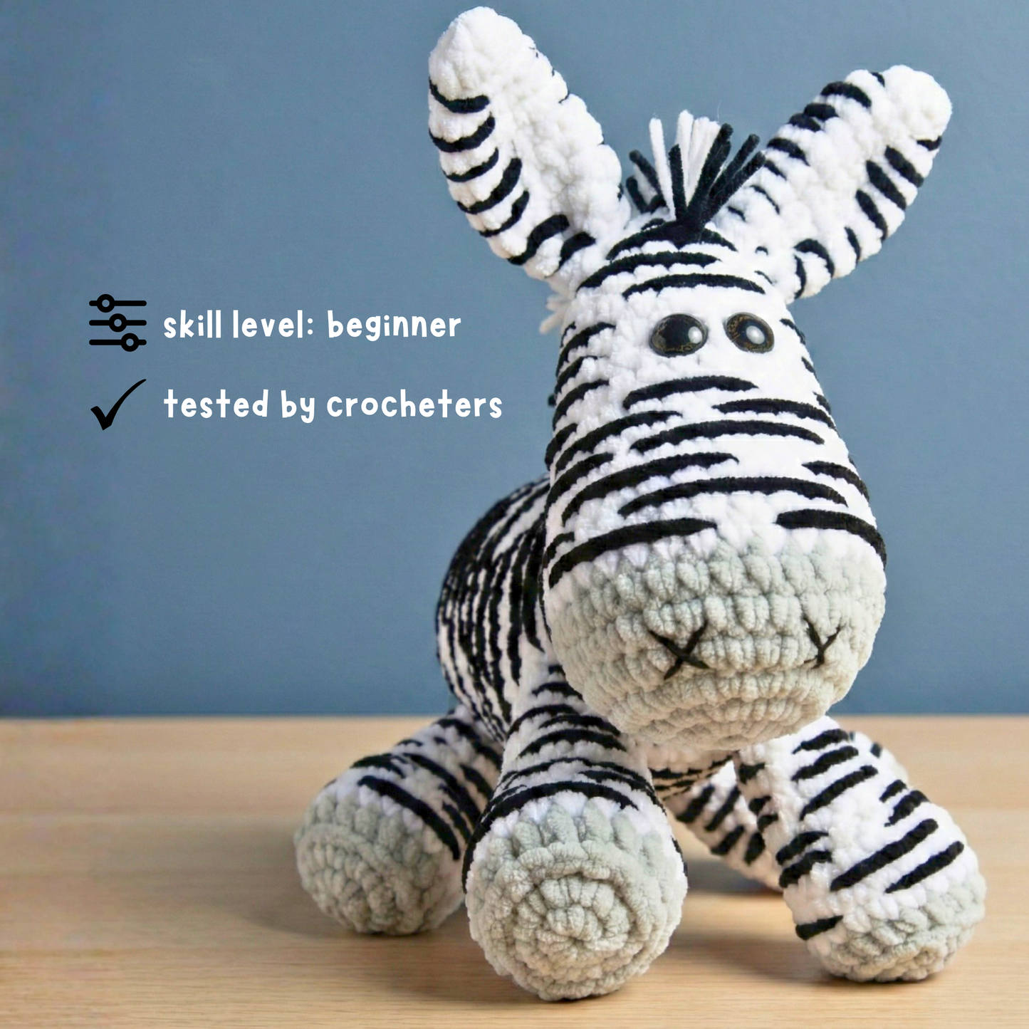 crocheted zebra plush toy with black and white stripes on wooden surface, beginner skill level