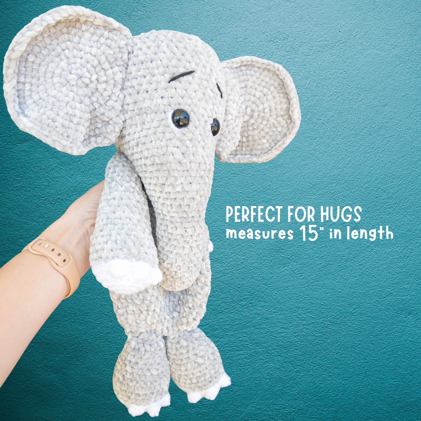 Hand holding a crocheted gray elephant plush toy against a teal textured background with text about size and comfort