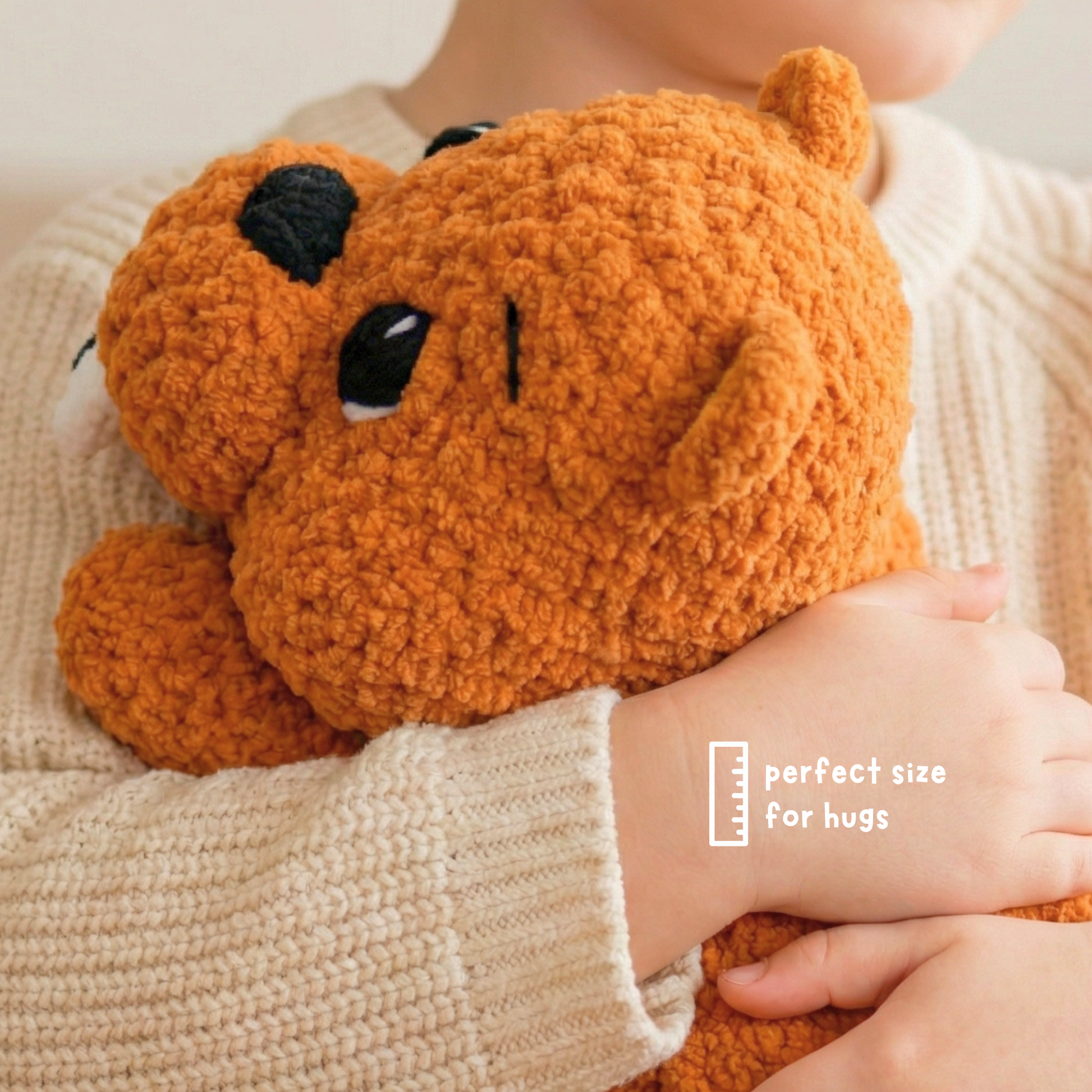 Child in cream sweater hugging soft orange plush bear toy, perfect size for hugs