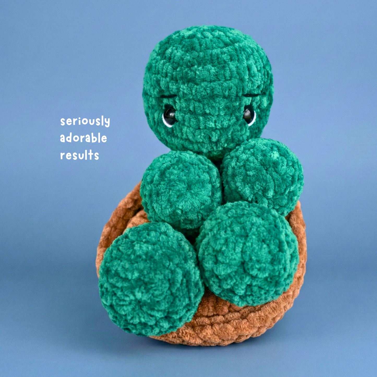 Handmade crocheted plush turtle with green textured body and brown shell on blue background