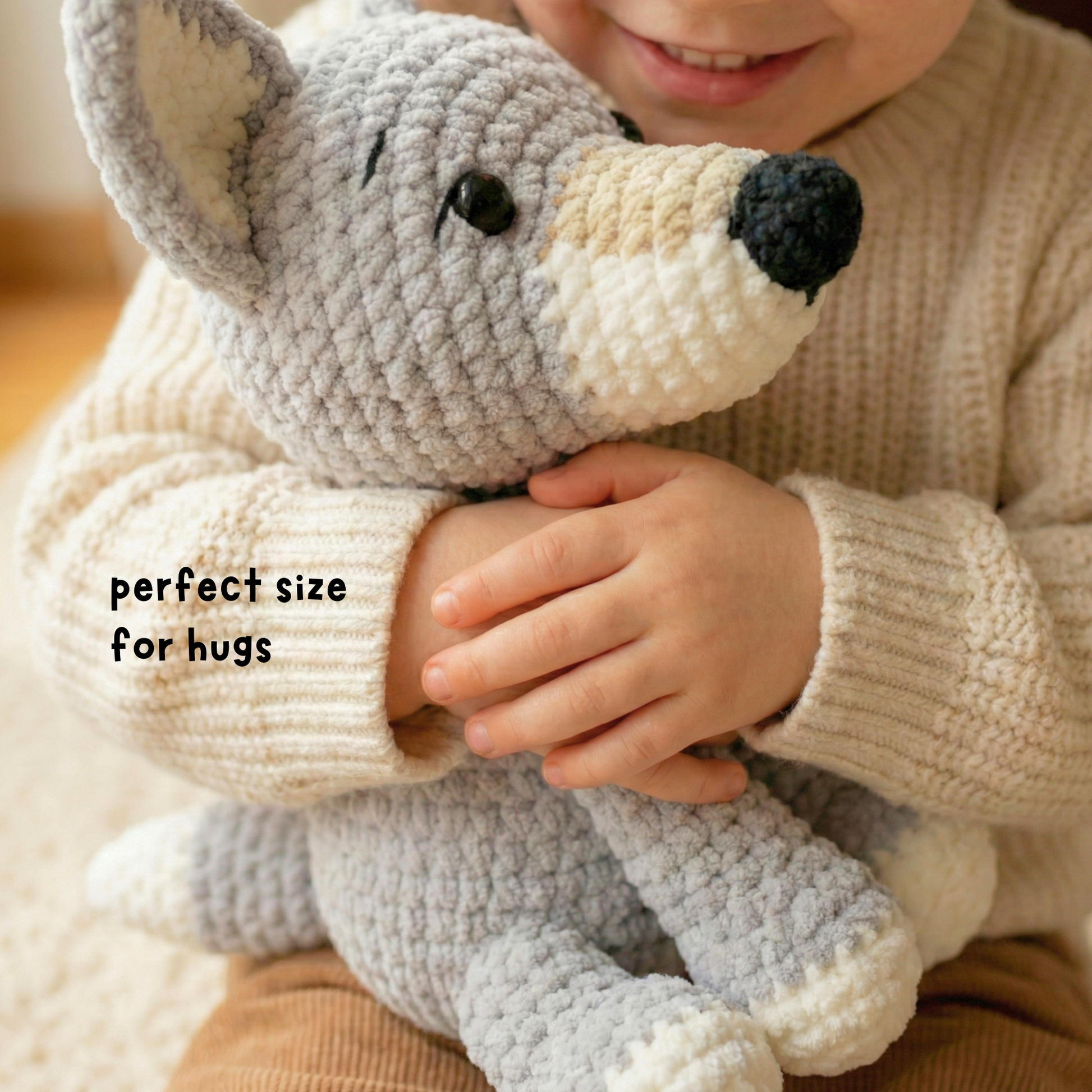 Child in beige sweater hugging soft gray crocheted plush dog toy, text reads perfect size for hugs