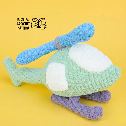 Green crocheted helicopter toy with blue rotor and purple landing skids on yellow background