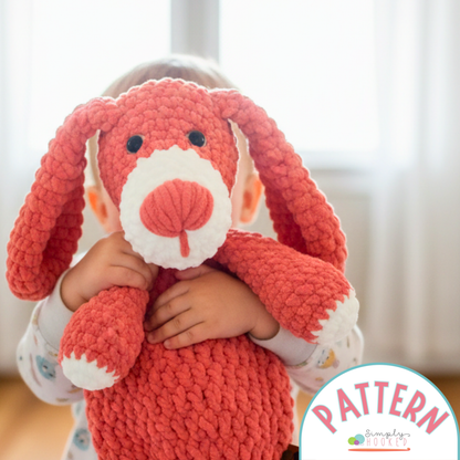 Child holding a red knitted bunny toy with 'Pattern' text overlay