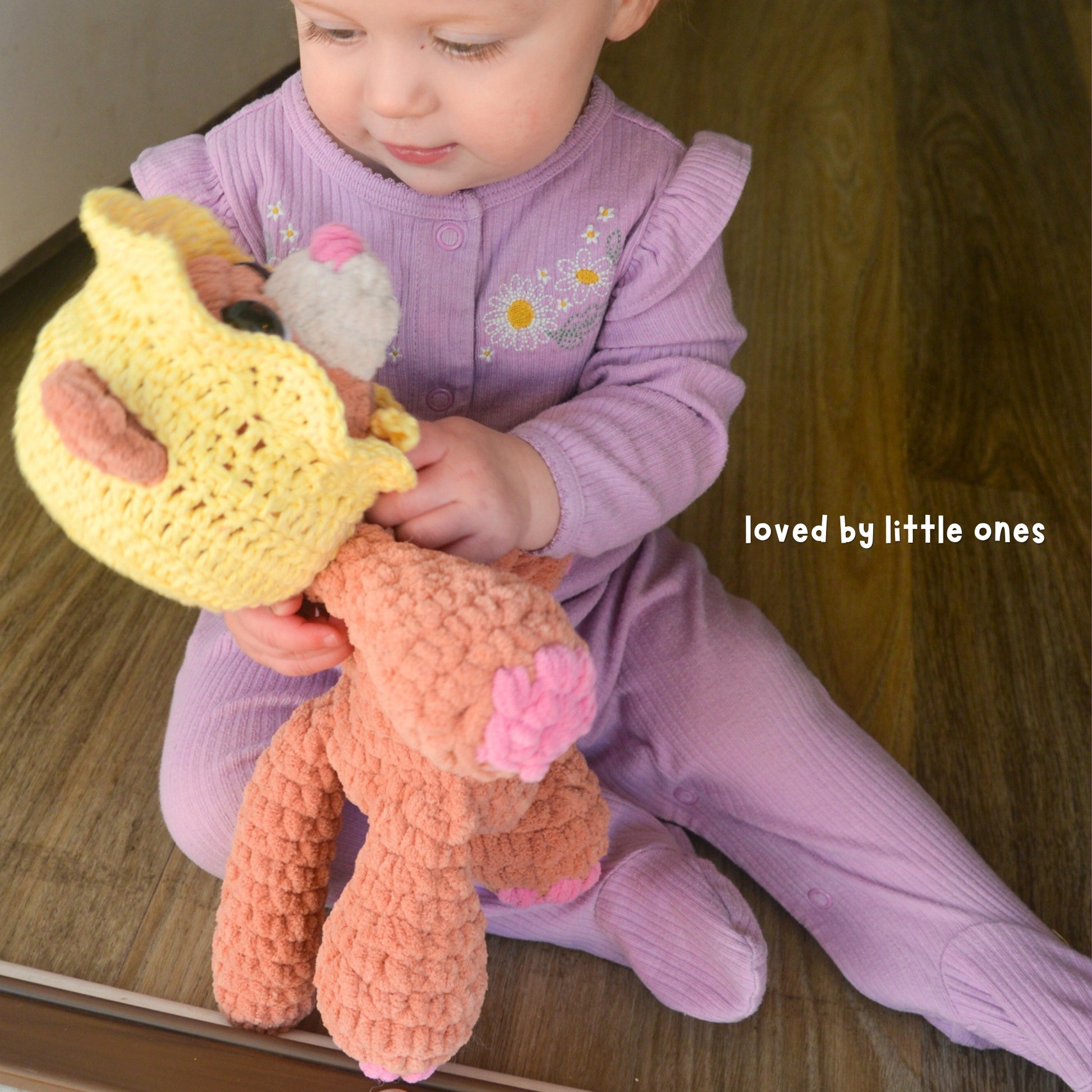 Child holding a knitted toy with 'loved by little ones' text