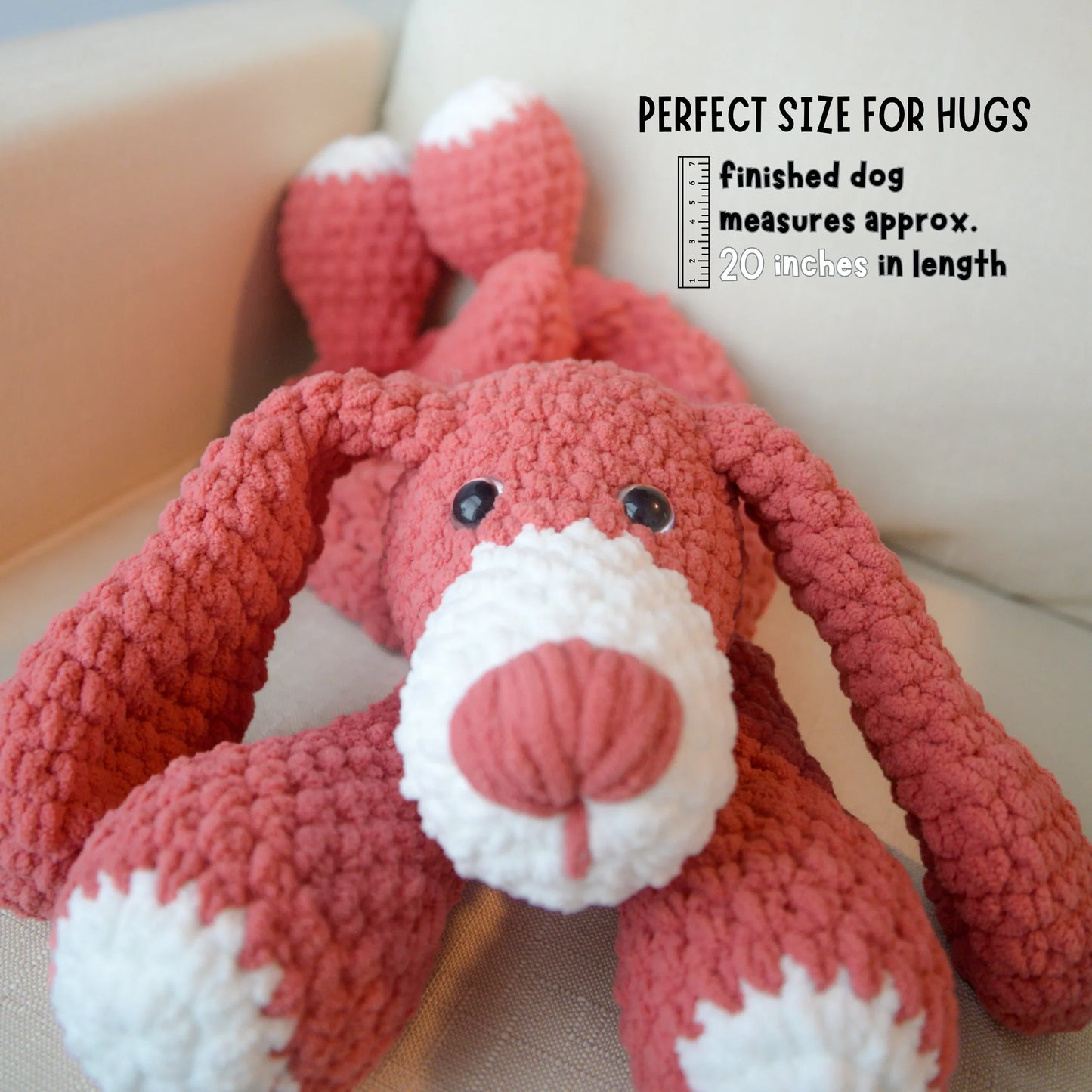 Crochet dog plushie laying down, amigurumi pattern, pink with white accents, 20 inches long