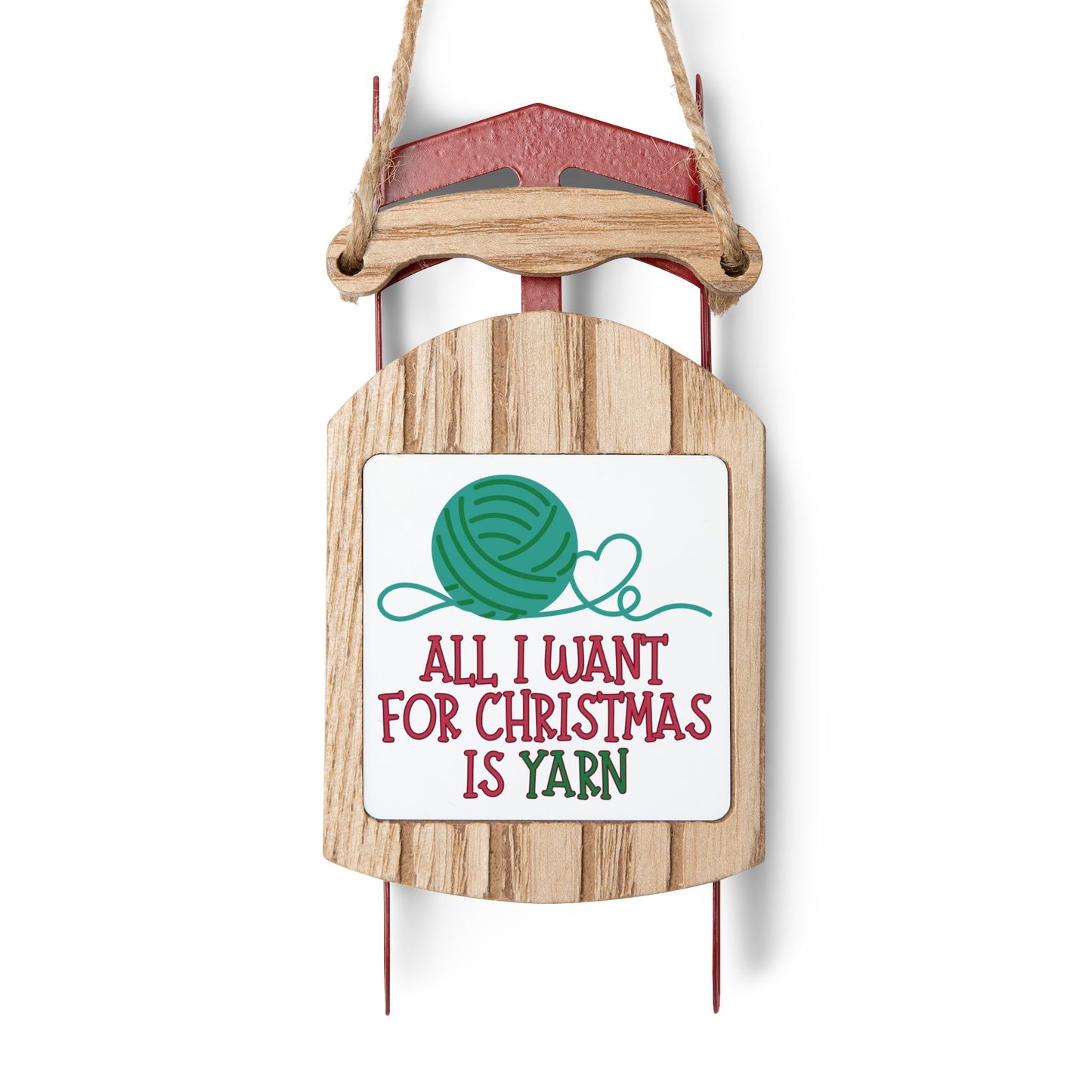 Wooden sled ornament with a sign saying 'All I want for Christmas is yarn' on a white background
