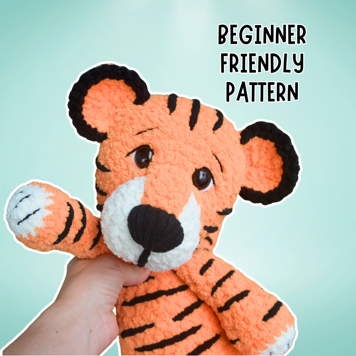 Hand holding a crocheted tiger toy with 'Beginner Friendly Pattern' text on a light blue background