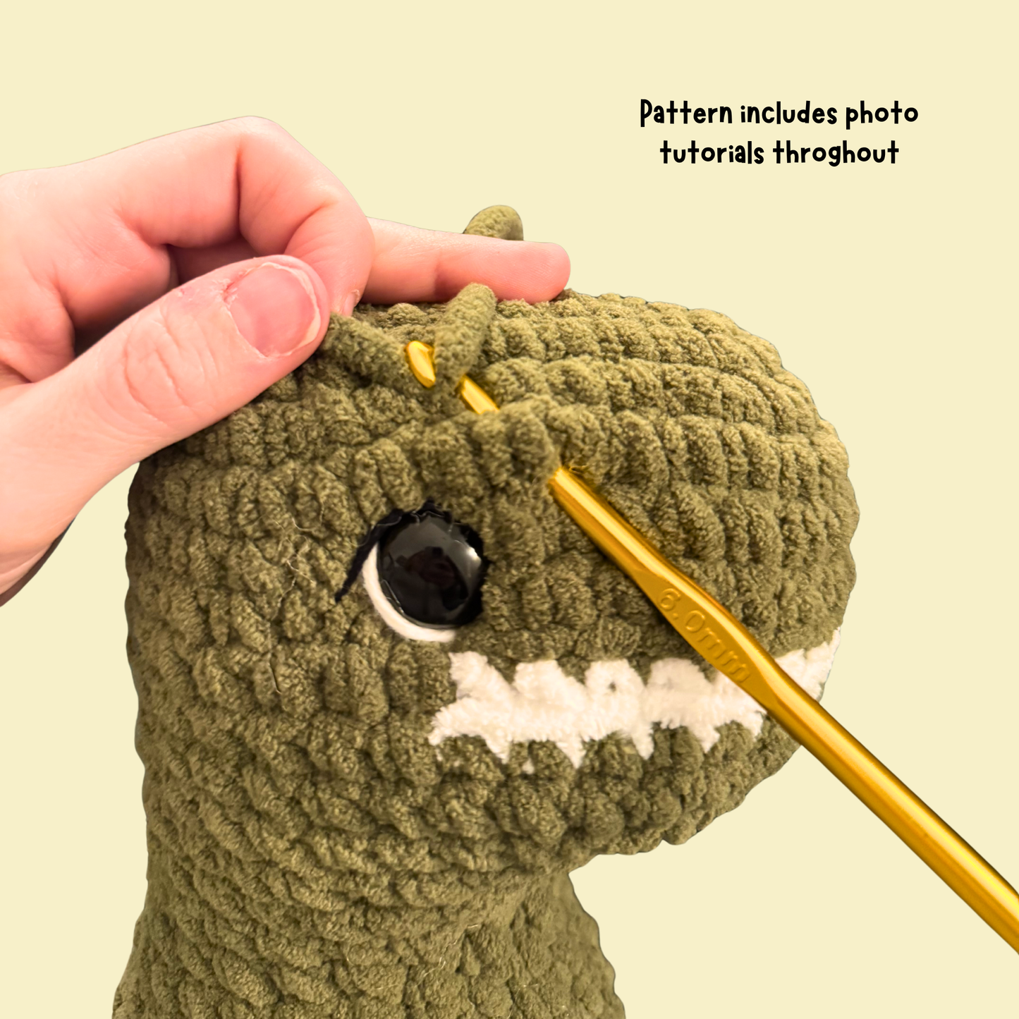 Hand crocheting a green plush toy with a gold crochet hook on a beige background.