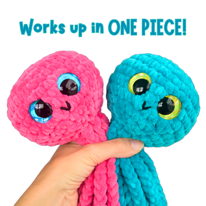 Hand holding pink and blue crocheted jellyfish plushies with large eyes and text 'Works up in ONE PIECE!' above.