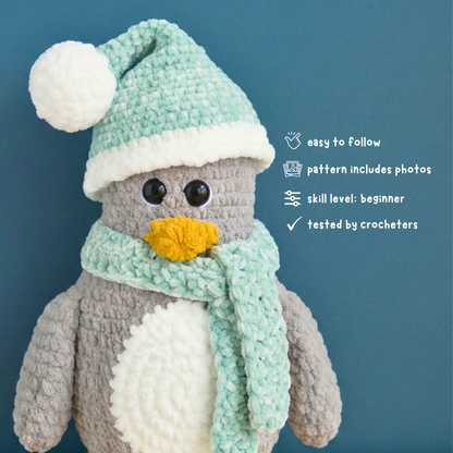 Crocheted penguin toy with a green hat and scarf on a blue background