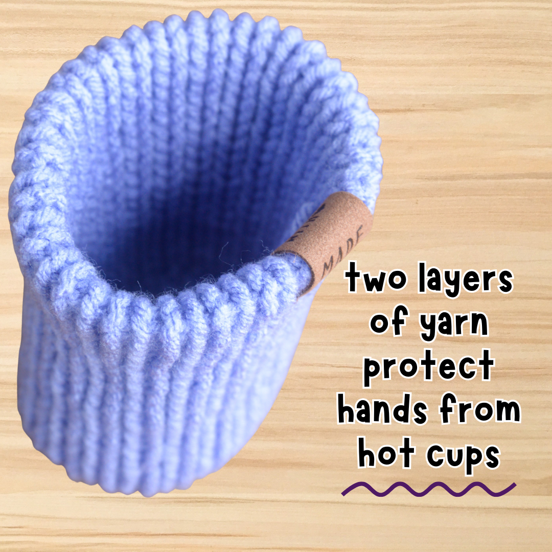 Blue knitted cup holder on a wooden surface with text indicating its use.