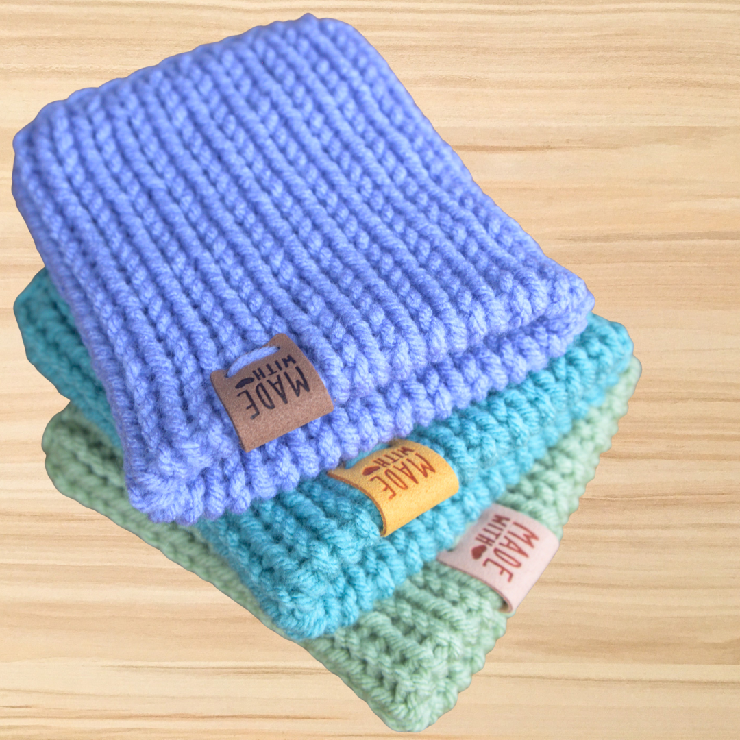 Stack of colorful folded towels with 'MADE' labels on a wooden surface