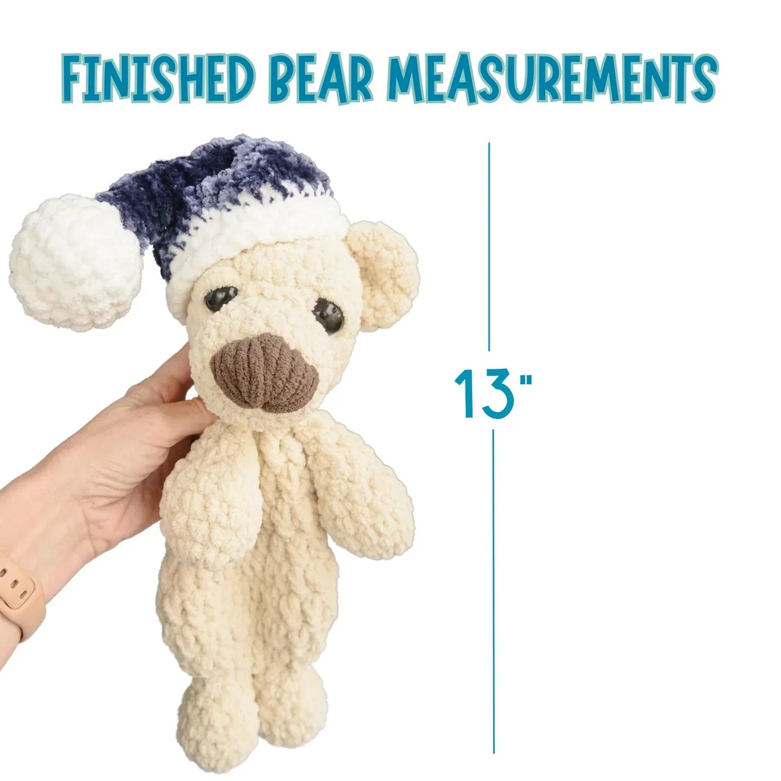 Hand holding a 13-inch crochet sleeping bear plushie with a blue and white hat