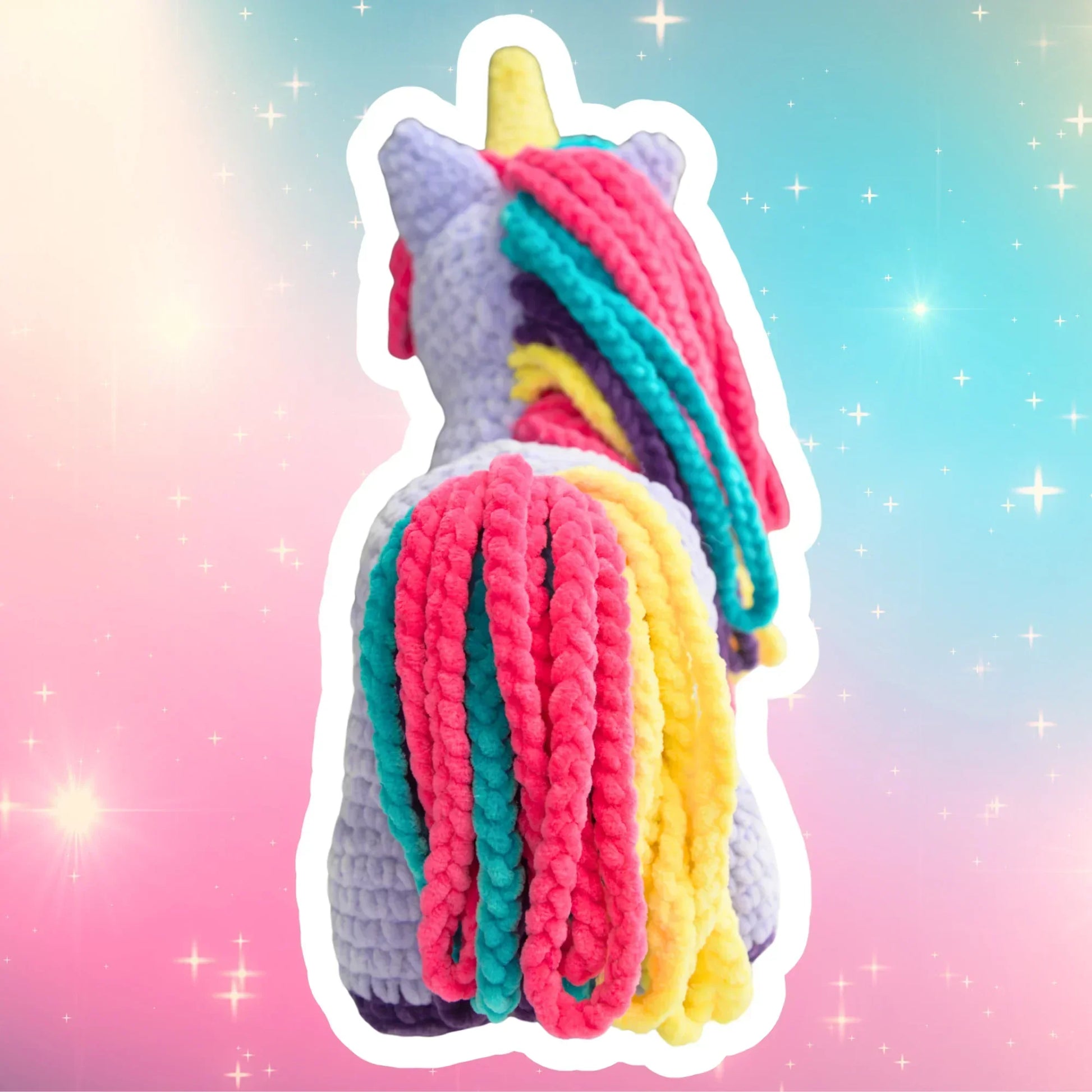 Plush crochet unicorn toy with colorful yarn mane and tail on pastel star background