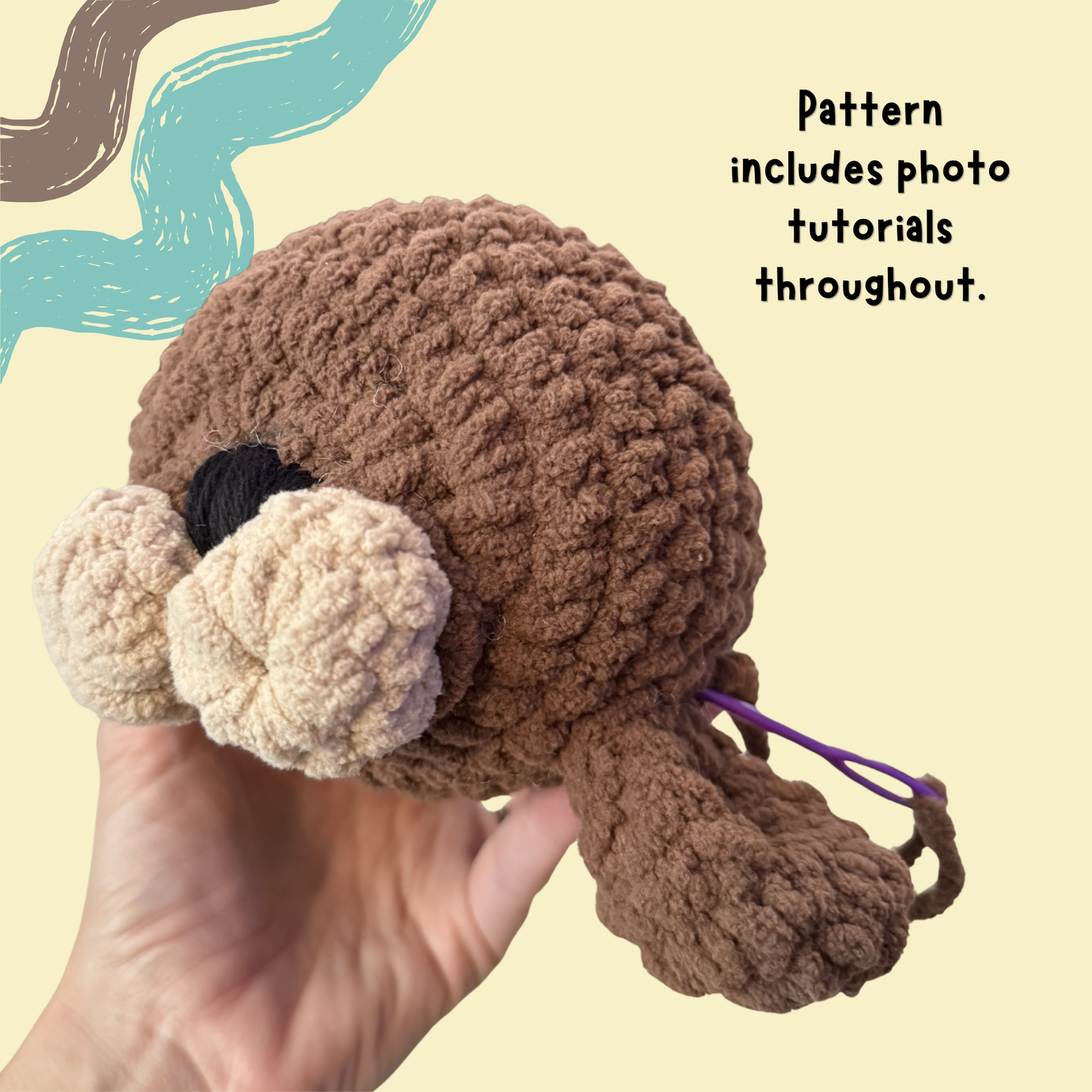 A hand holds a crocheted plush toy with a brown body, cream-colored snout and feet, and a black eye, against a pale yellow background with decorative brushstroke graphics and text stating 'Pattern includes photo tutorials throughout.'.