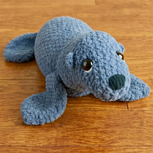 Adorable blue crochet seal amigurumi with big eyes, perfect for beginner crocheters