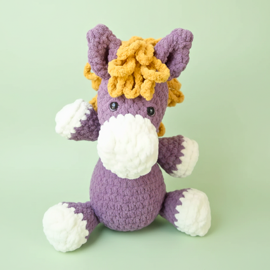 purple crochet horse plushie with white snout and hooves, yellow mane, amigurumi pattern