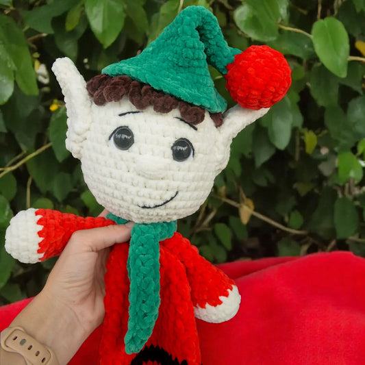crochet elf plushie with green hat and scarf, red outfit, and large black eyes