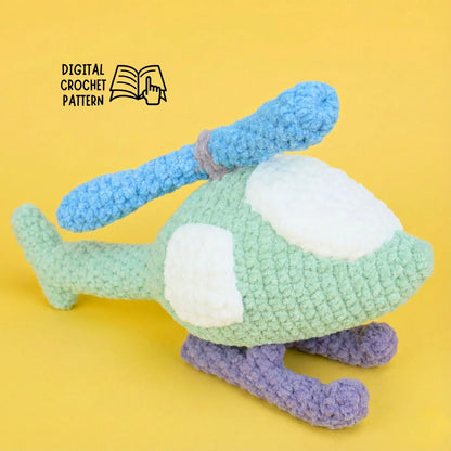 Plush crochet helicopter amigurumi with blue rotors and purple skids on yellow background