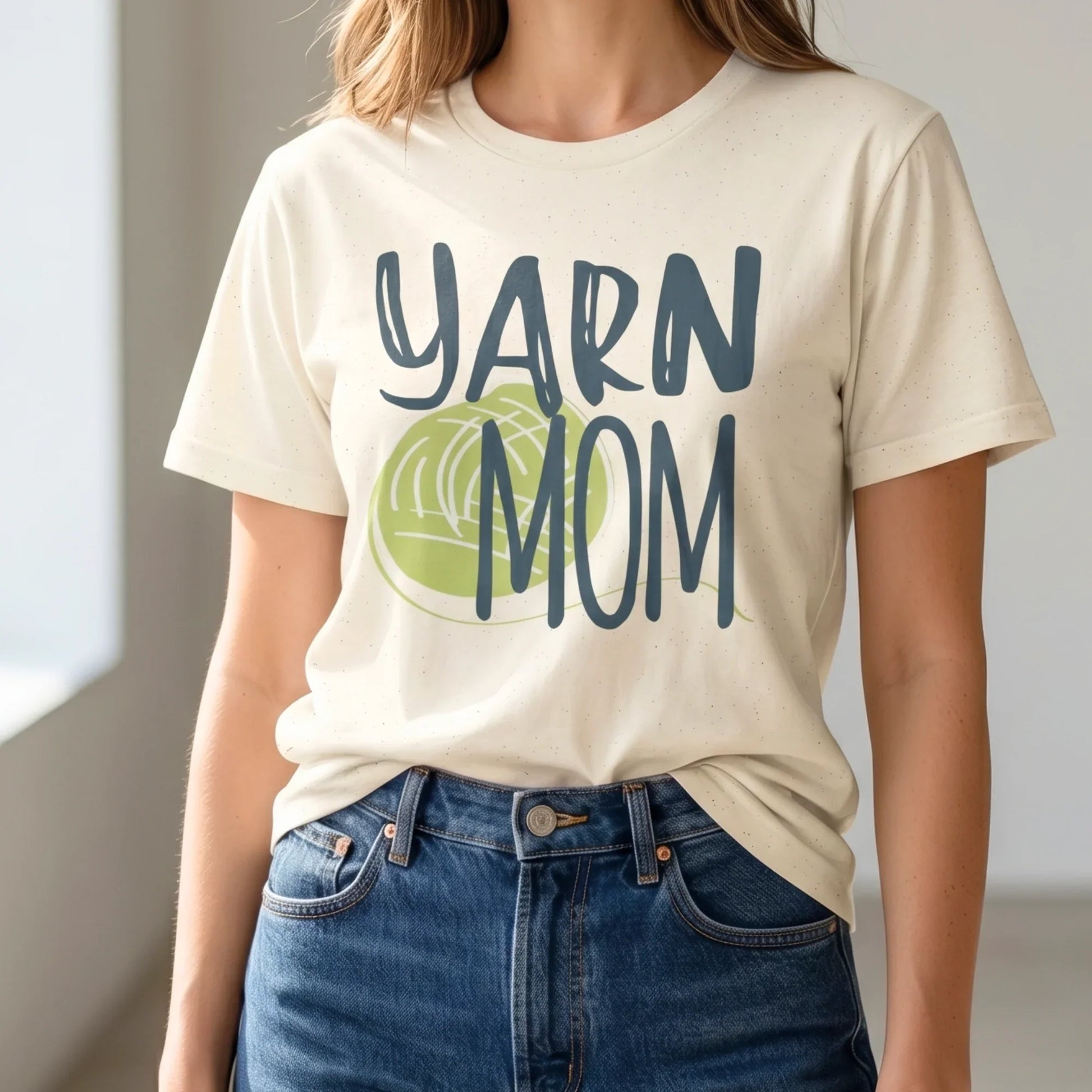 Person wearing a t-shirt with 'YARN MOM' text and a green yarn ball graphic.