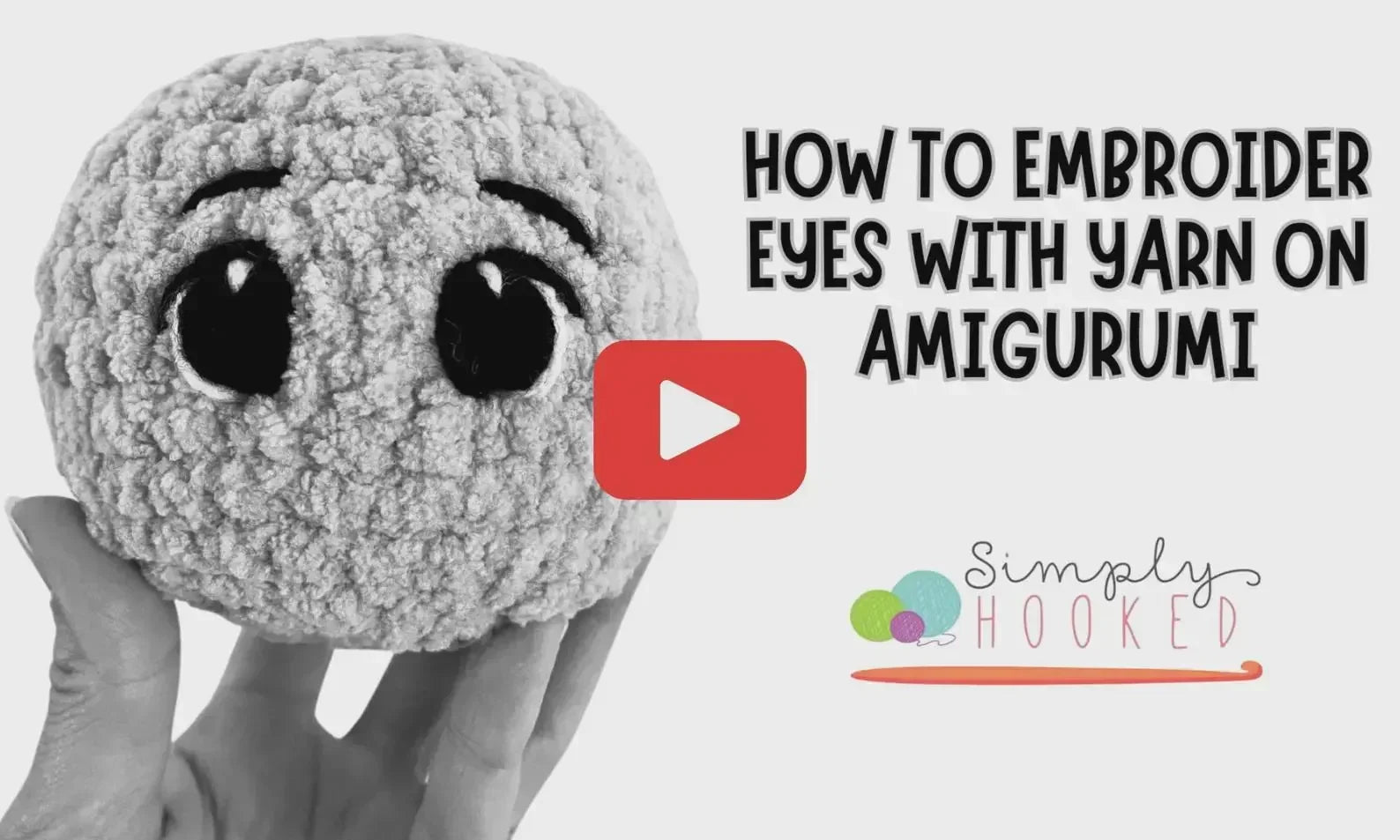 Hand holding a crochet amigurumi plush with embroidered yarn eyes, tutorial video thumbnail.