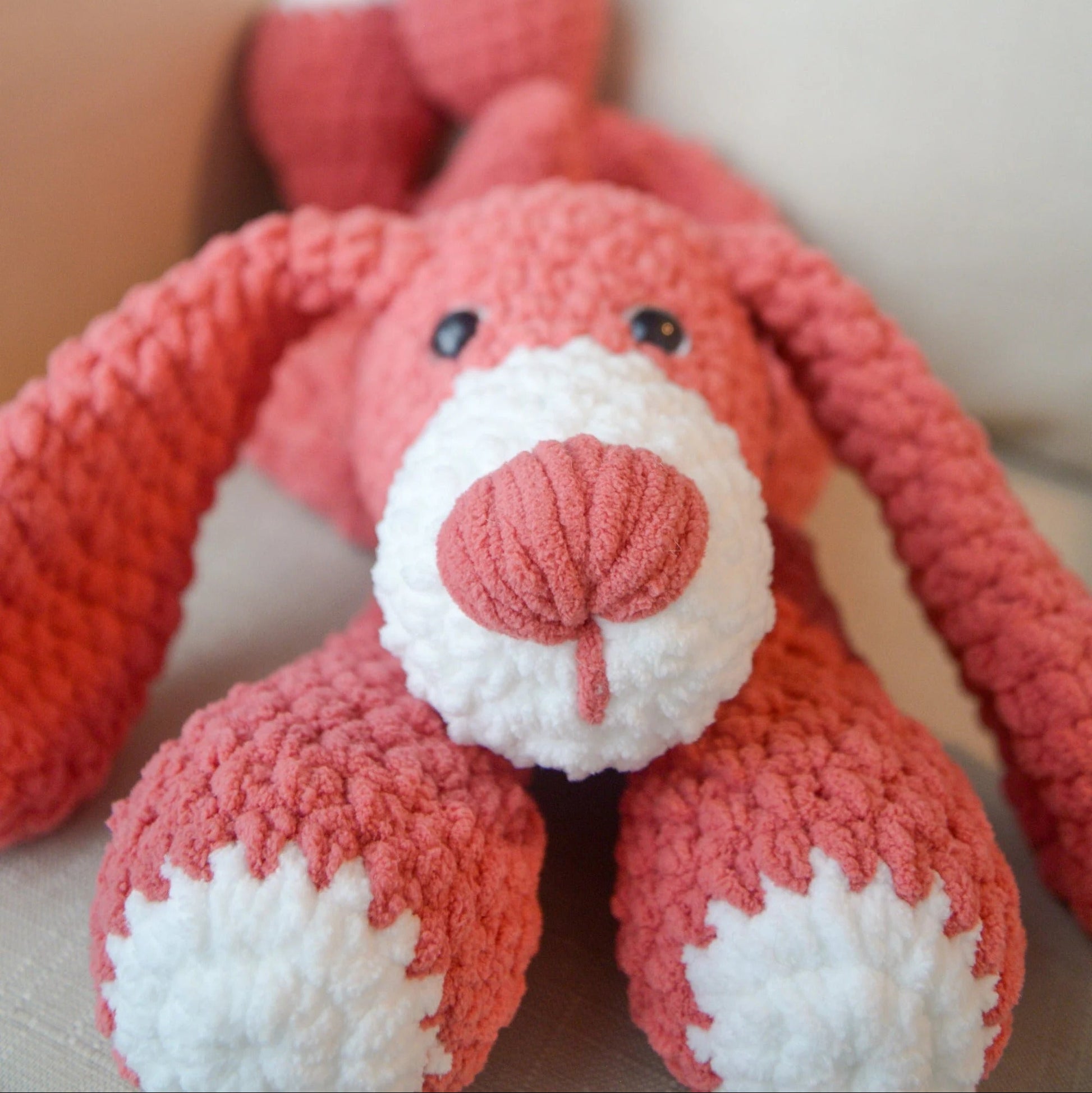 Close-up of a red and white knitted dog toy on a light background