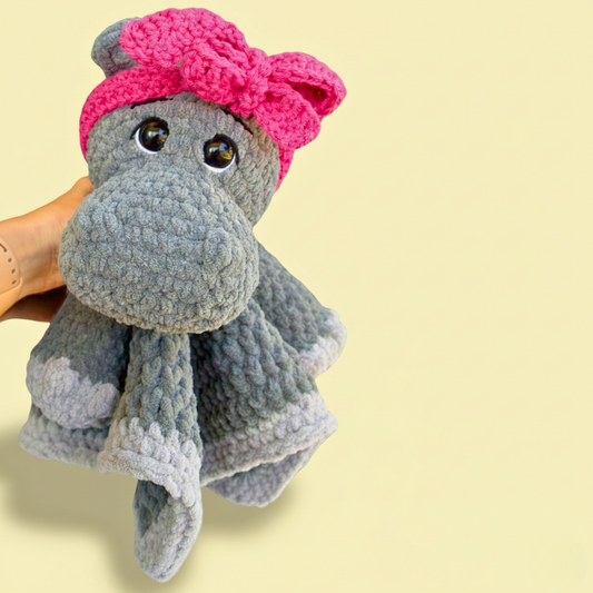 crochet hippo lovey plushie with pink headband, gray body, handmade amigurumi blanket toy