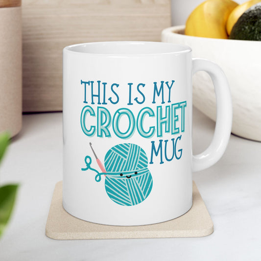 White mug with 'This is my crochet mug' text and yarn ball design on a coaster.