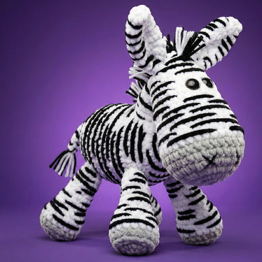 Crocheted zebra toy on a purple background